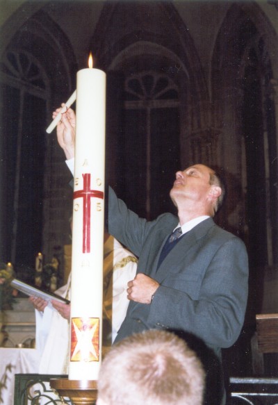 David lighting the boys' candles from the Easter candle